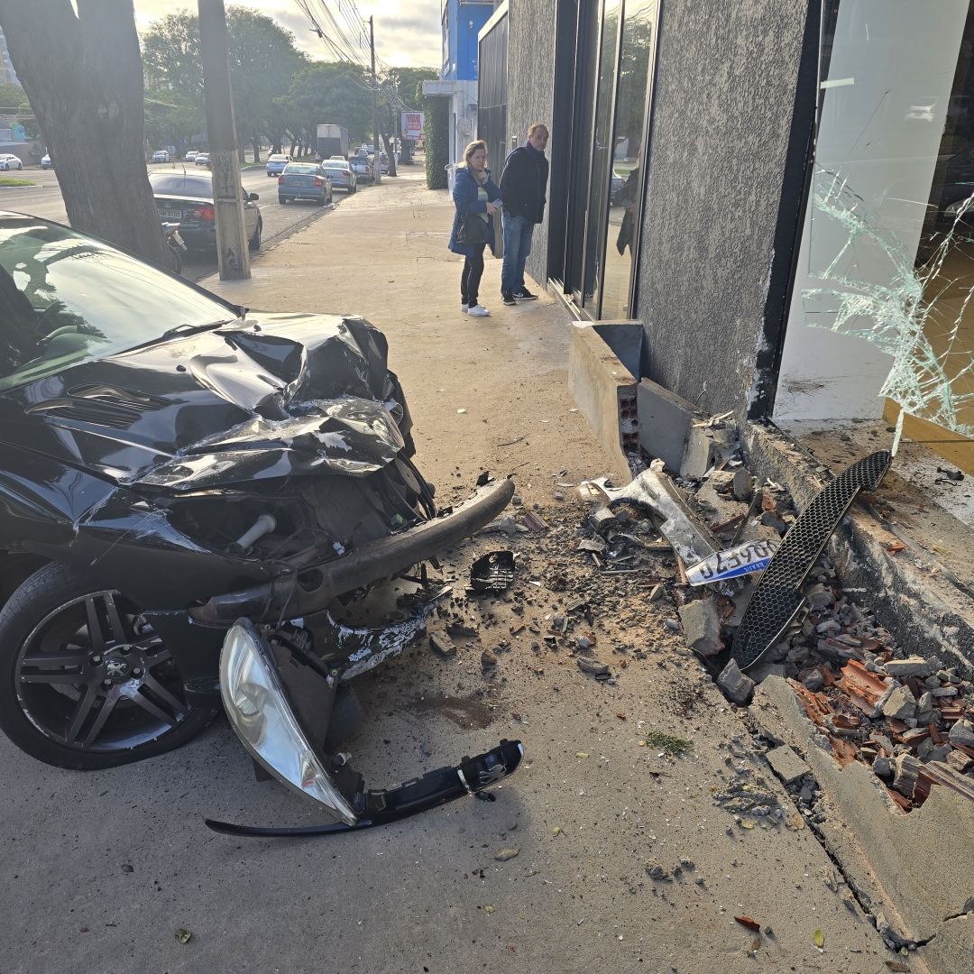 Carro sobe na calçada e atinge vidraça de empresa após batida na Avenida Colombo
