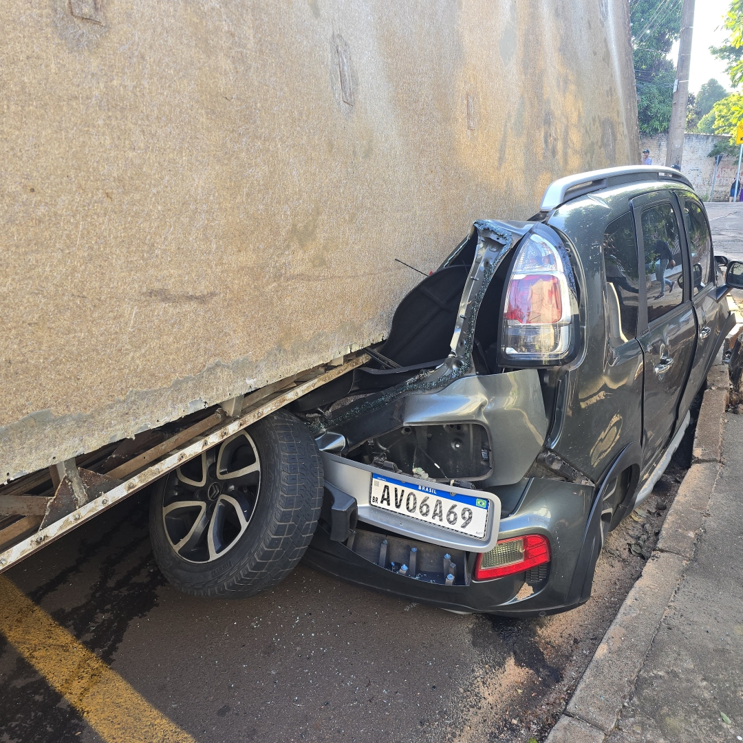 Automóvel fica destruído após carreta tombar e cair sobre automóvel