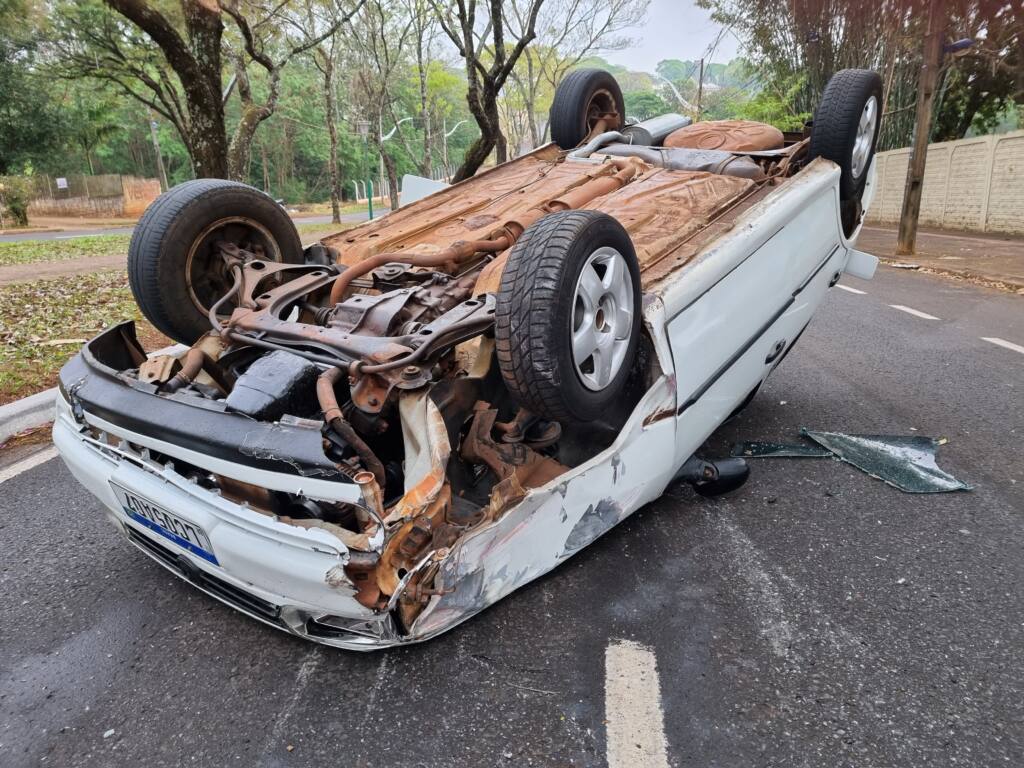 Veículo capota após bater em outro carro estacionado